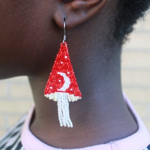 handmade crescent moon and mushroom patterned earring on model