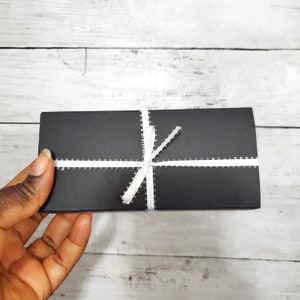 This shows how your package will arrive to you: in a black jewelry box and white ribbon. I hold it against a white and black background.