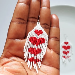 Red and White Heart Earrings placed in palm