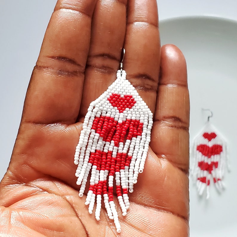 Red and White Heart Earrings placed in palm