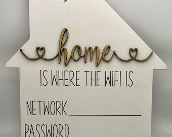 Könnte beinhalten: Weißes, hausförmiges Schild aus Holz mit dem Text "home is where the wifi is" und Platz zum Eintragen des Netzwerknamens und des Passworts.