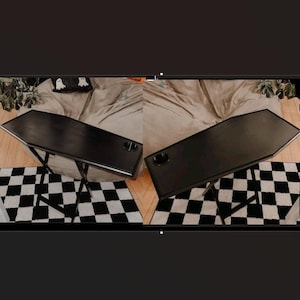 May include: Two black folding tables with a checkered black and white rug underneath. The tables have a black top and black legs.