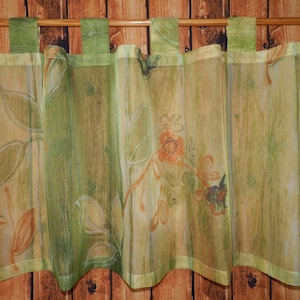 Könnte beinhalten: Ein Satz durchsichtiger Vorhänge mit einem Blumendruck in Grün-, Orange- und Brauntönen. Die Vorhänge haben einen gewellten Saum und sind an einer Holzstange aufgehängt.