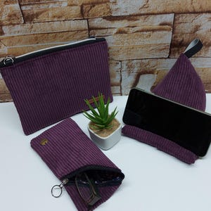 Könnte beinhalten: Set aus drei Beuteln aus violettem Cord. Ein Beutel ist ein großer Beutel mit Reißverschluss, ein anderer ist ein kleinerer Beutel mit Reißverschluss und Schlüsselring, und der dritte ist ein dreieckiger Beutel mit einem schwarzen Riemen.