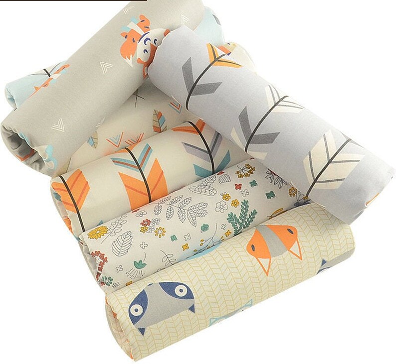 May include: A set of six fabric scraps featuring different patterns, including arrows, flowers, and animals. The fabrics are in shades of gray, blue, orange, and white.