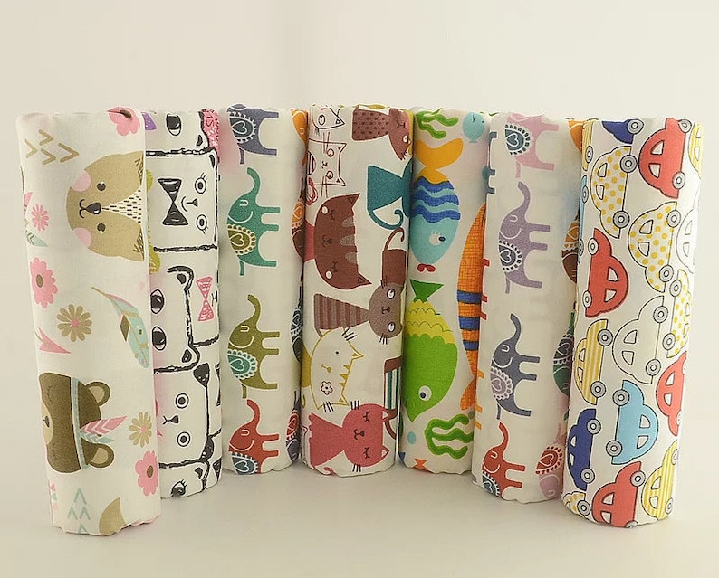 May include: Set of eight fabric panels with different colorful animal and vehicle prints. The panels are white with various colored designs, including cats, fish, elephants, and cars.