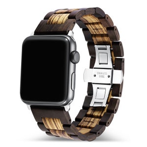 May include: A brown wood and stainless steel Apple Watch band. The band has a dark brown wood finish with light brown wood accents. The band is secured with a stainless steel clasp that says "Stainless Steel".
