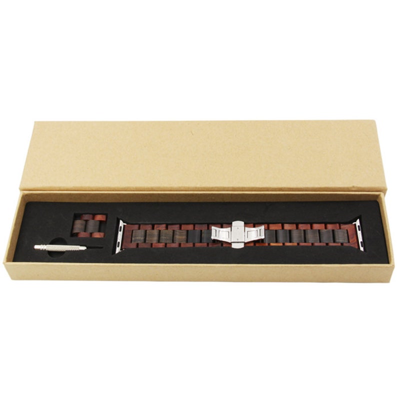 May include: A wooden watch band in a brown box. The band is made of dark and light wood and has a silver metal clasp.
