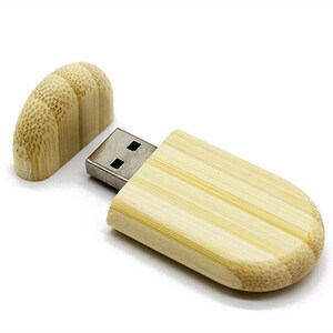 K&ouml;nnte beinhalten: Ein USB-Stick aus Holz mit nat&uuml;rlicher Bambus-Oberfl&auml;che. Der Stick hat eine Schiebekappe, die den USB-Anschluss freigibt.