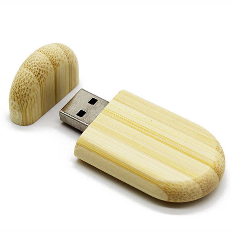 K&ouml;nnte beinhalten: Ein USB-Stick aus Holz mit nat&uuml;rlicher Bambus-Oberfl&auml;che. Der Stick hat eine Schiebekappe, die den USB-Anschluss freigibt.