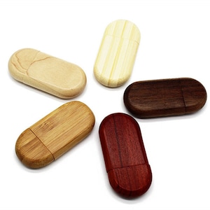 Puede incluir: Cinco unidades flash USB de madera en diferentes acabados de madera: natural, marrón claro, marrón oscuro y rojo. Las unidades son de forma ovalada y tienen un acabado liso y pulido.