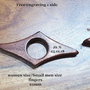 May include: Three wooden bookmark rings in different sizes. The smallest ring is 1.9 inches in diameter, the middle ring is 2.1 inches in diameter, and the largest ring is 2.4 inches in diameter. The rings are engraved with the text "Alexandre", "J&N 25.12.18", and "Merry xmas Papa".