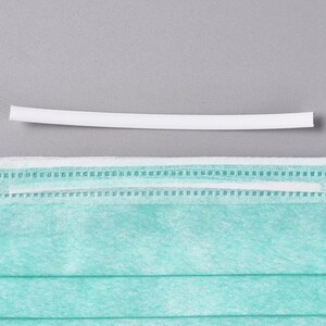May include: A white plastic nose wire for a face mask. The nose wire is about 6 inches long.