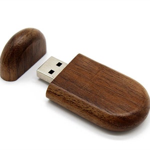 K&ouml;nnte beinhalten: Ein USB-Stick aus Holz mit brauner Holzoptik. Der Stick hat eine Kappe, die &uuml;ber den USB-Stecker gleitet.