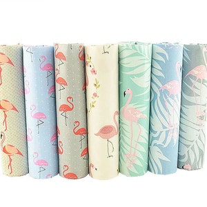 May include: A set of seven fabric panels featuring pink flamingos on various backgrounds. The panels include a light blue background with white polka dots, a gray background with white polka dots, a cream background with pink flowers, a light green background with palm leaves, a light blue background with palm leaves, a gray background with white polka dots, and a light green background with palm leaves.
