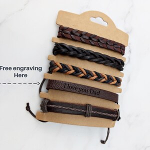 May include: Set of five brown leather bracelets with a braided design. The bottom bracelet has the text "I love you Dad" engraved on it. Free engraving is available.