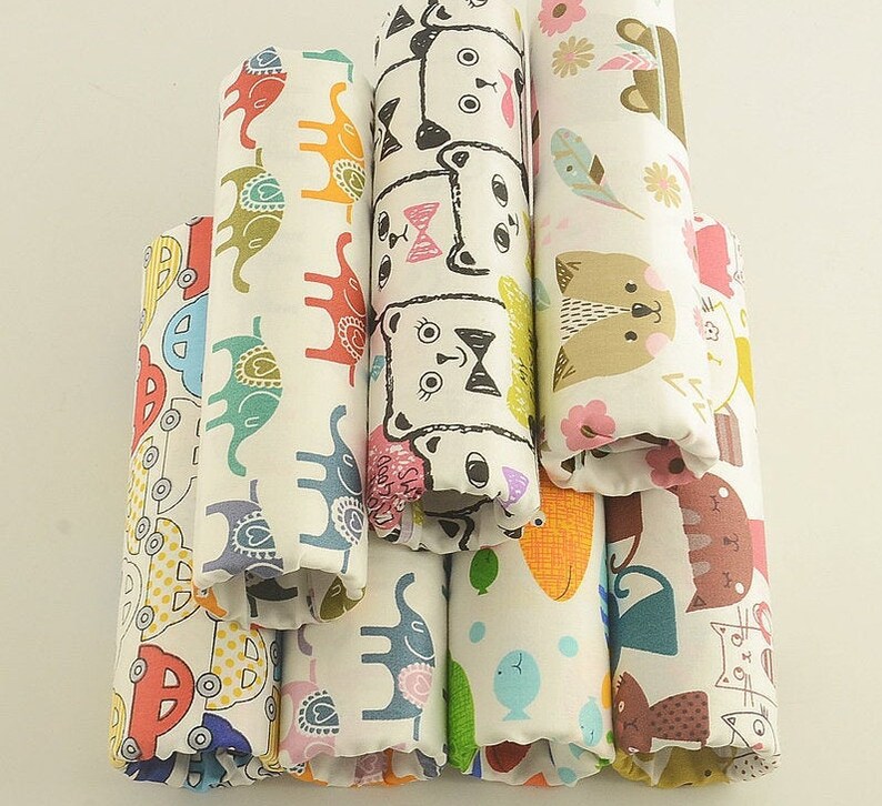 May include: A stack of eight fabric scraps with different colorful patterns. The patterns include animals, geometric shapes, and floral designs. The fabric is white with a variety of colors.