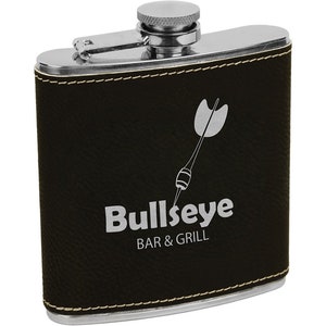 May include: A stainless steel hip flask with a black leatherette cover. The flask features a silver dart graphic and the text "Bullseye BAR & GRILL" in silver. It has a silver cap and trim with white stitching.
