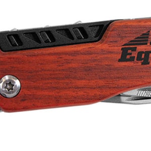 May include: A multi-tool with an adjustable stainless steel wrench and a reddish-brown wooden handle. The handle has the text "Brogan Equipment" in black. The wrench is marked "Stainless".