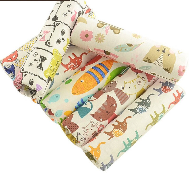 May include: A set of six fabric scraps featuring various colorful animal and fish designs. The designs include cats, elephants, fish, and birds. The fabric is a light beige color with a subtle texture.
