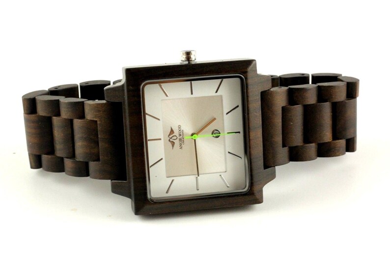 May include: A square-shaped wooden wristwatch with a brown wooden band. The watch face is white with black markings and the text "AMARE WOOD" in the center.