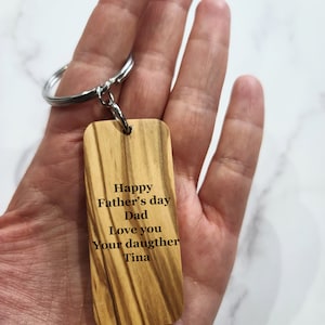 Pode incluir: Chaveiro de madeira com uma mensagem personalizada: "Feliz Dia dos Pais Pai Amo você Sua filha Tina"