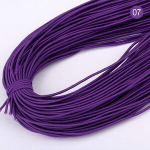 May include: A spool of purple elastic cord. The cord is approximately 100 yards long and is perfect for crafting projects.
