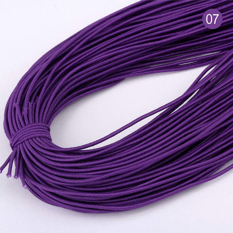 May include: A spool of purple elastic cord. The cord is approximately 100 yards long and is perfect for crafting projects.