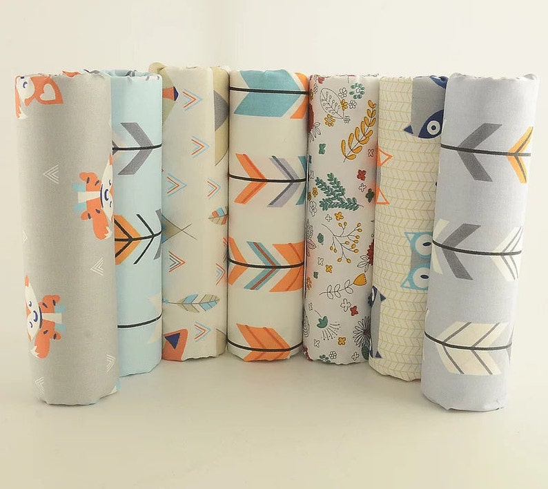 May include: Six fabric swatches with different patterns, including arrows, owls, and floral designs. The swatches are in shades of gray, blue, orange, and white.