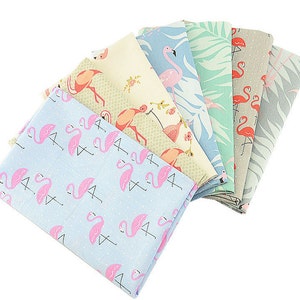 May include: A set of six fabric squares featuring pink flamingos on a variety of backgrounds, including light blue, green, and beige. The fabrics are perfect for quilting, crafting, or home decor projects.