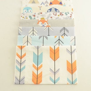 May include: A stack of eight fabric squares with different patterns. The patterns include arrows, foxes, and woodland animals. The fabrics are in shades of blue, orange, gray, and white.
