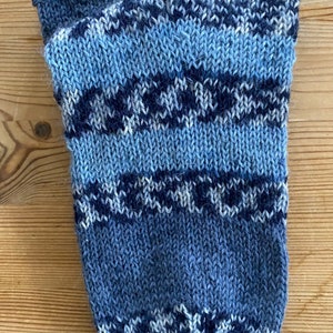 May include: A blue and white striped knitted sock with a pointed toe.