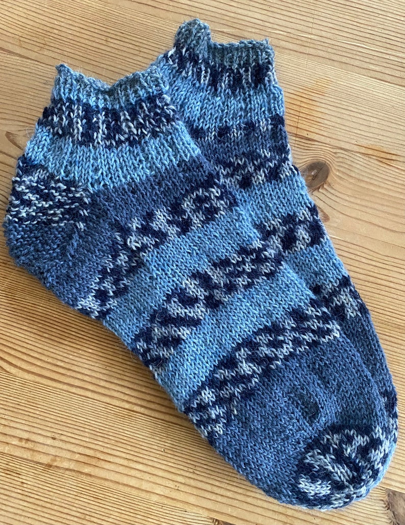 May include: A pair of blue and white patterned ankle socks. The socks are knitted and have a geometric design.