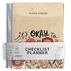 May include: A spiral-bound planner with a tan cover featuring the text ALISHA HIGGINS and it's OKAY to, decorated with red and pink floral illustrations. A white paper band wraps around the center with the text CHECKLIST PLANNER and doodles.