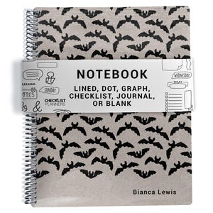 May include: A spiral-bound notebook with a tan cover featuring a repeating black bat pattern. A white paper band wraps around the center with the text NOTEBOOK LINED, DOT, GRAPH, CHECKLIST, JOURNAL, OR BLANK, CHECKLIST PLANNERS, and Bianca Lewis.