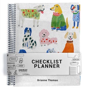 Könnte beinhalten: Ein spiralgebundener Planer mit weißem Einband und bunten Illustrationen verschiedener Hunde in Pullovern. Ein Papierband umschließt die Mitte mit dem Text "CHECKLIST PLANNER" und "Brianne Thomas" am unteren Rand.
