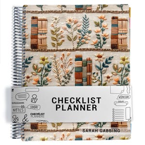 May include: A spiral-bound planner with a cream-colored cover featuring embroidered illustrations of flowers and stacks of books. A white paper band wraps around the center, printed with the text CHECKLIST PLANNER and SARAH GABBING.