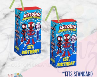 May include: Two rectangular juice box covers featuring a blue spiderweb pattern, cartoon characters, and the text Antonio and Amazing Friends 1st Birthday. Each cover includes a light green straw and fits standard size juice boxes for parties.