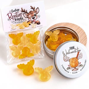 May include: A clear plastic bag of yellow reindeer-shaped gummy candies with a label reading "lustige Rentier-köpfe zum vernaschen" and a metal tin containing more gummies with a label reading "FROHE Weihnachten EIERPUNSCH ELCHE ALKOHOLFREI".