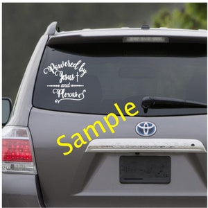 Puede incluir: Un coche gris con una calcomanía de vinilo blanco en la ventana trasera que dice "Powered by Jesus + and Plexus".