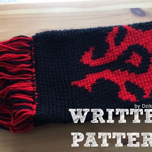 Könnte beinhalten: Ein schwarz-roter gestrickter Schal mit einem roten Drachenmuster und Fransen. Der Schal trägt den Text "WRITTEN PATTERN" in Weiß auf einer Holzoberfläche darunter.