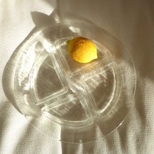 May include: A white ceramic mug with a black handle and the text "But First, Coffee" in a black, handwritten-style font. The mug is on a white surface.