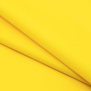 May include: A close-up of a bright yellow fabric with a smooth texture. The fabric is folded in a way that creates a diagonal line.