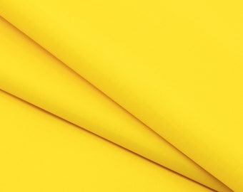May include: A close-up of a bright yellow fabric with a smooth texture. The fabric is folded in a way that creates a diagonal line.