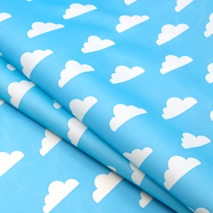 May include: A blue fabric with a white cloud pattern. The fabric is folded in half, showing the pattern on both sides.
