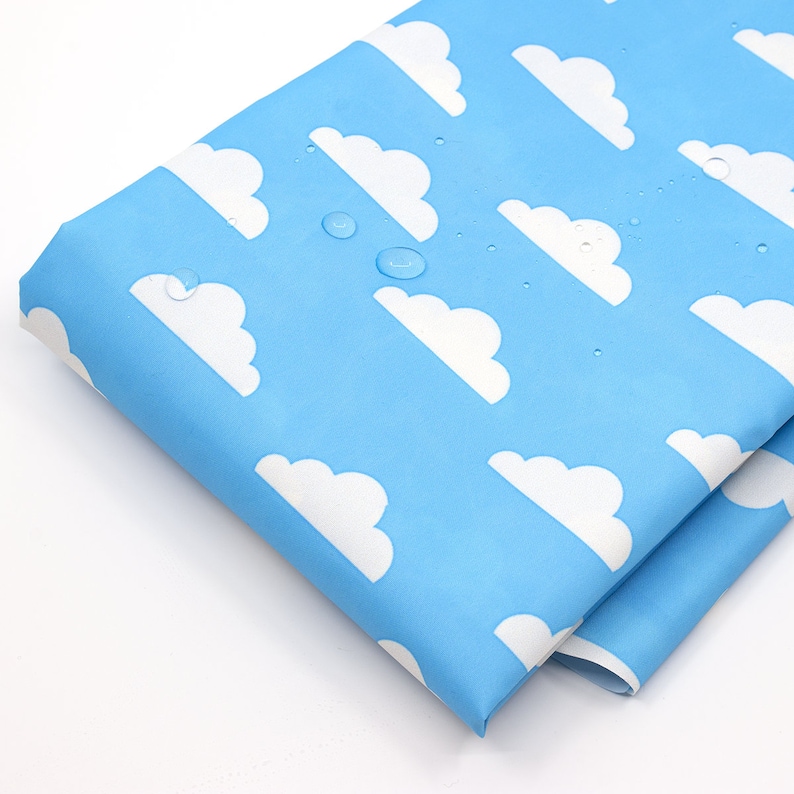 May include: A close-up of a light blue fabric with a white cloud pattern. The fabric is waterproof and has water droplets on it.