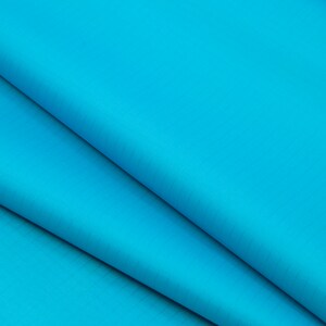May include: Close-up of a folded piece of bright blue fabric with a subtle textured pattern.