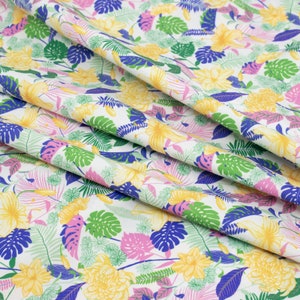 May include: White fabric with a tropical print featuring yellow, pink, green and blue flowers and leaves.