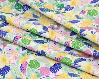 May include: White fabric with a tropical print featuring yellow, pink, green and blue flowers and leaves.