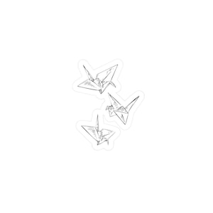 Op de afbeelding: Een sticker met drie origami-kraanvogels in vlucht. De kraanvogels zijn getekend in een minimalistische zwart-wit stijl, met zichtbare lijnen en schaduwen om de vouwen van het papier weer te geven. Witte achtergrond.